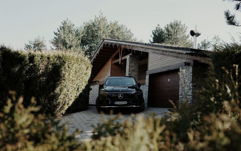A black car parked in the driveway of a house