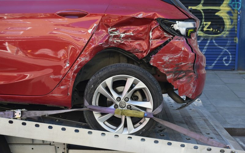 a red car is on a flatbed tow truck