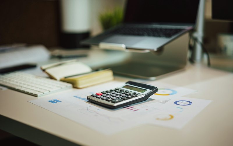 a calculator sitting on top of a table next to a laptop