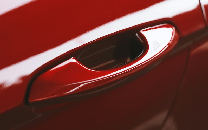 a close up of a red car door handle