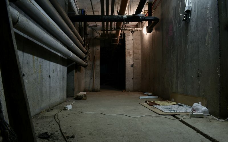 a dark room with pipes and a sheet of paper on the floor