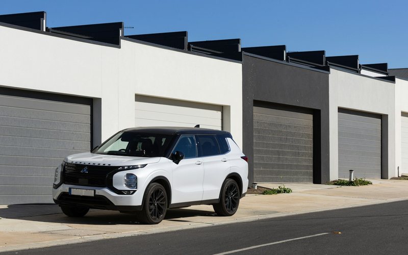 White suv parked in front of modern garages
