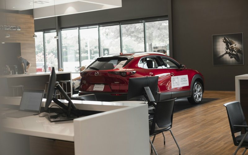 a red car is parked in a showroom