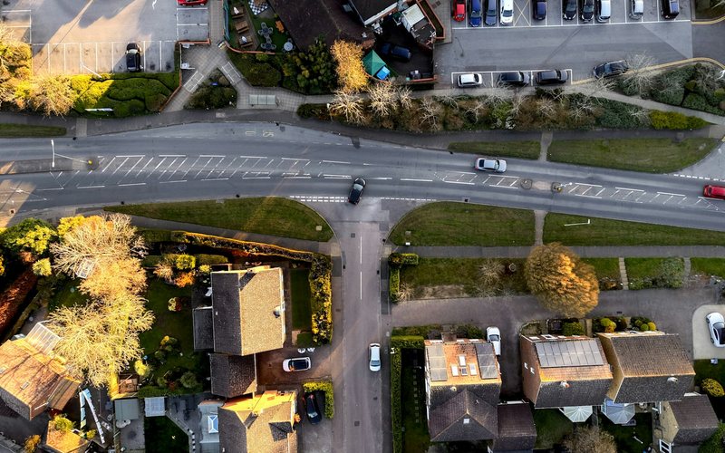Aerial view of a suburban street with cars and houses