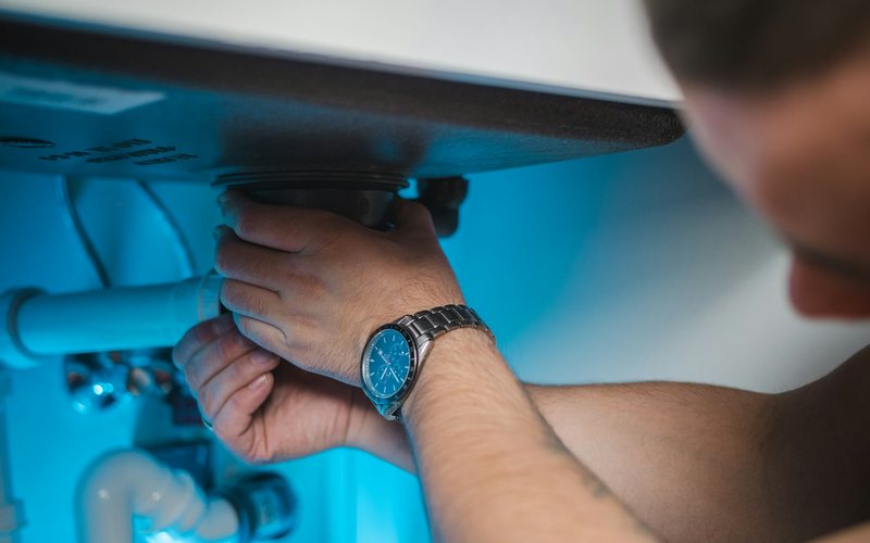 a man fixing a water heater in a room
